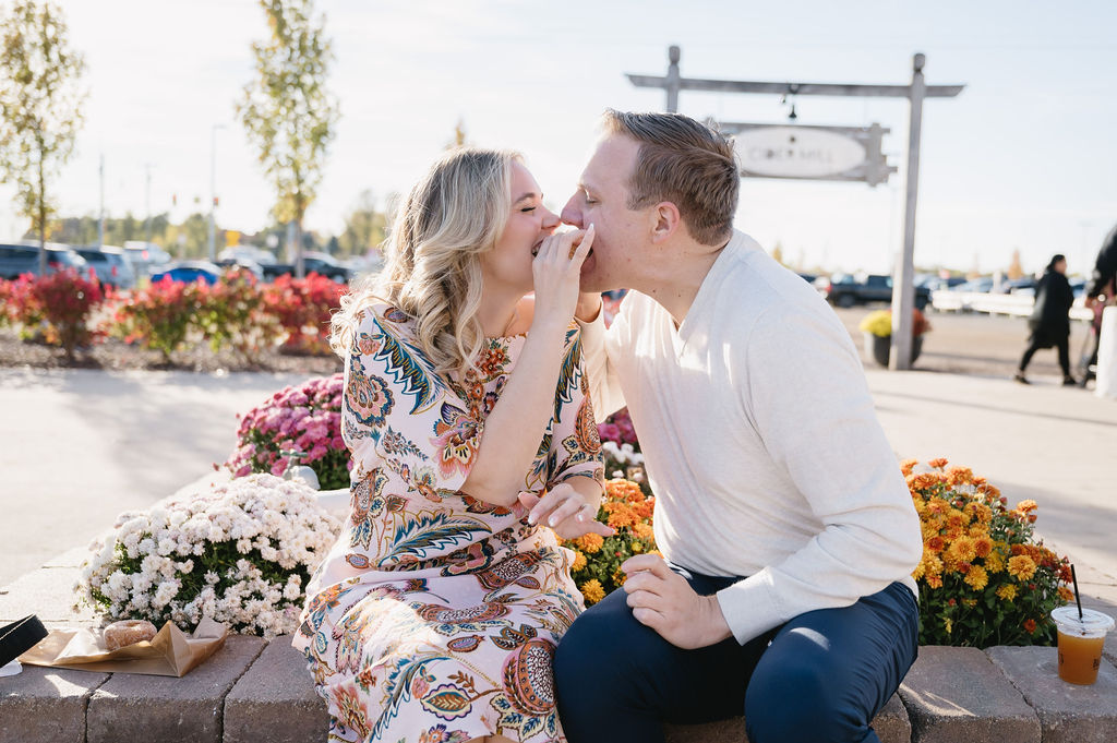 engaged couple eating cider donuts