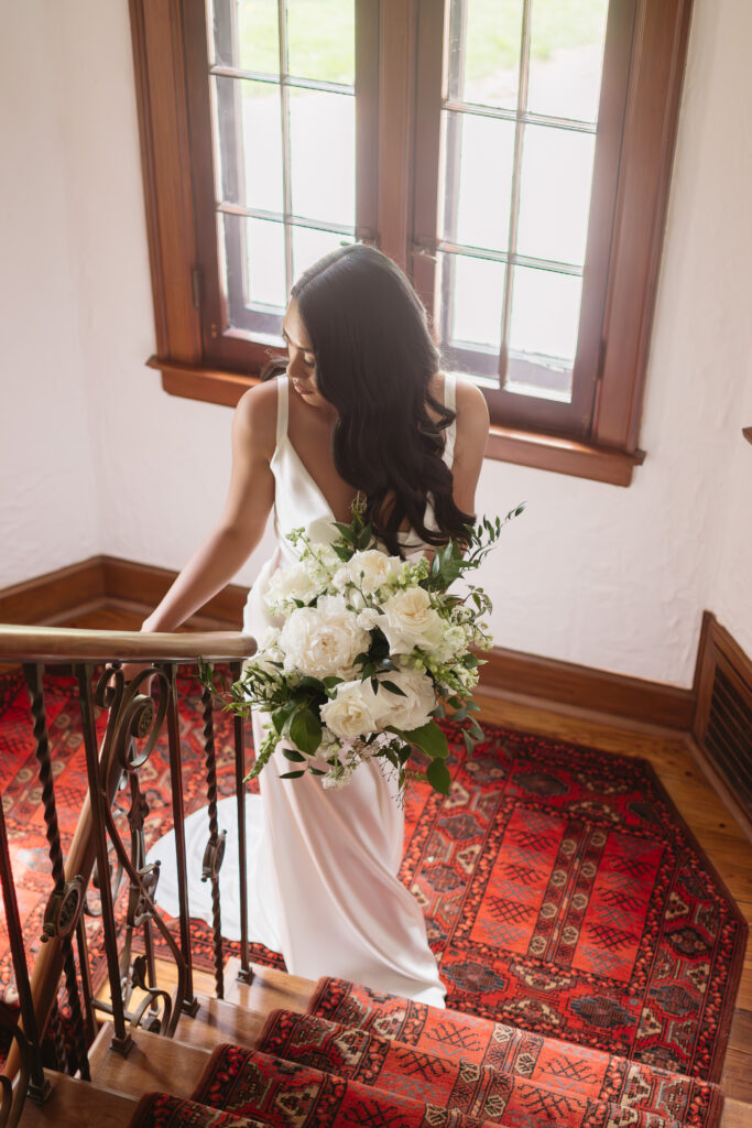 bride standing on staircase at Adams Manor, a Michigan wedding venue