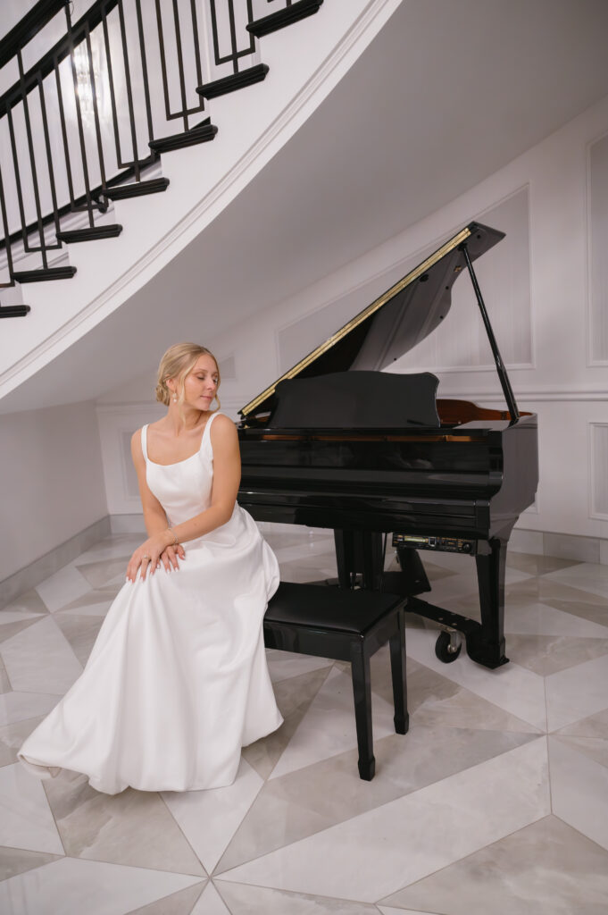 bride sitting in front of grand piano at The Palazzo Grande, a Sterling Heights Michigan wedding venue