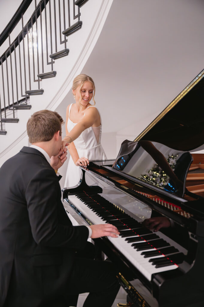 married couple sitting at piano together at The Palazzo Grande, a Michigan wedding venue