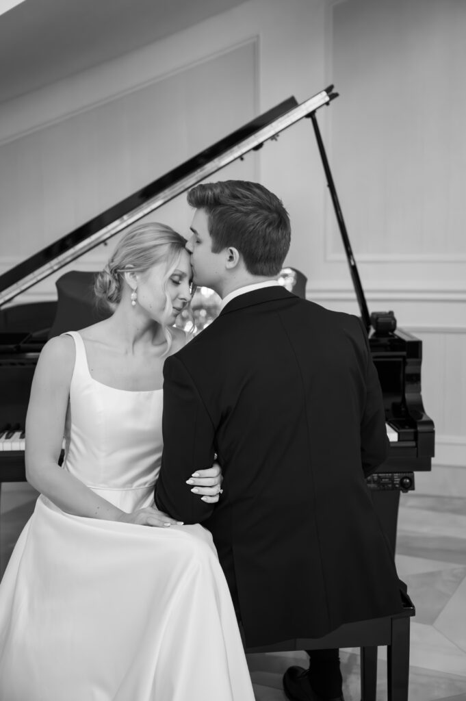 bride and groom sitting in front of grand piano at The Palazzo Grande, a wedding venue in Sterling Heights Michigan