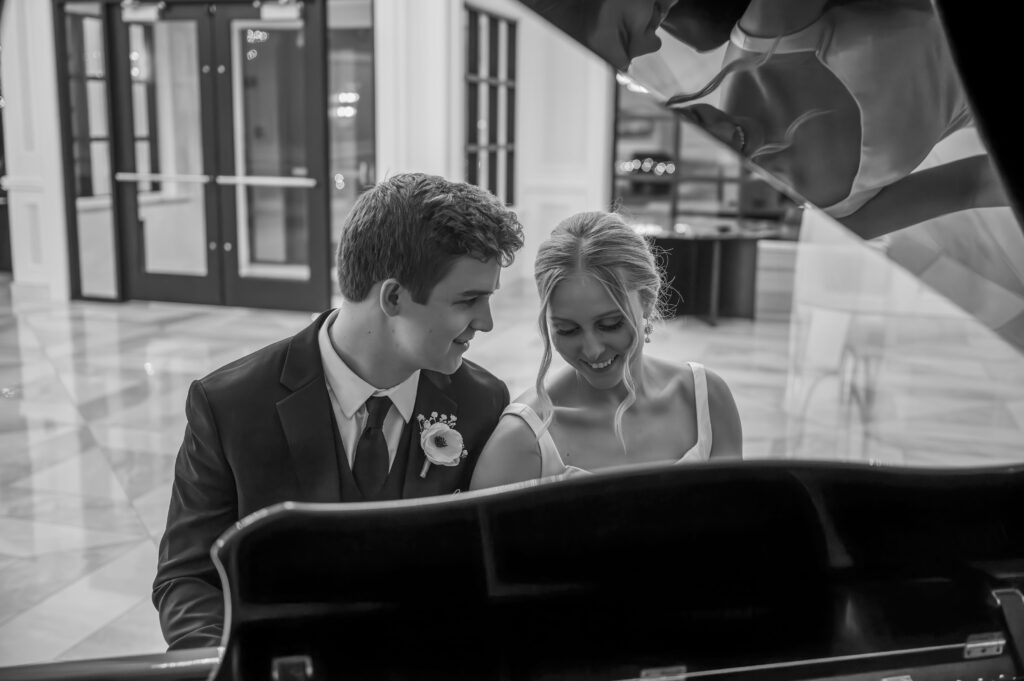 bride and groom playing grand piano at The Palazzo Grande, a wedding venue in Sterling Heights Michigan