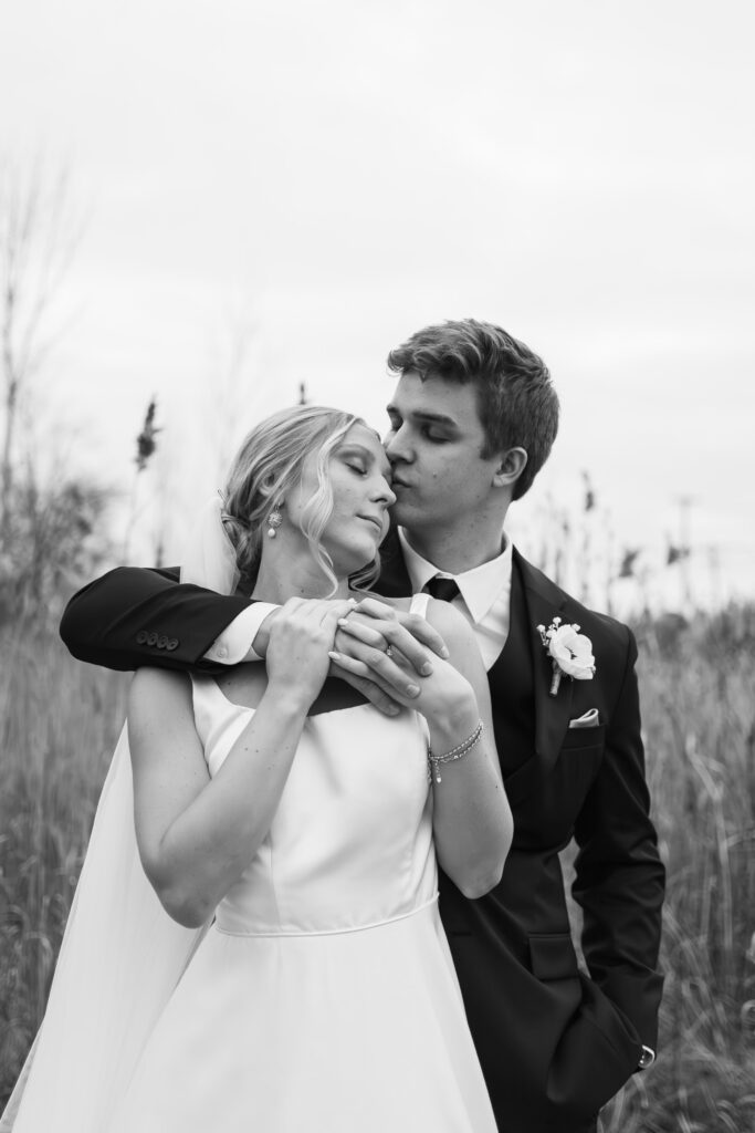 bride and groom hugging in open field near The Palazzo Grande in Sterling Heights Michigan