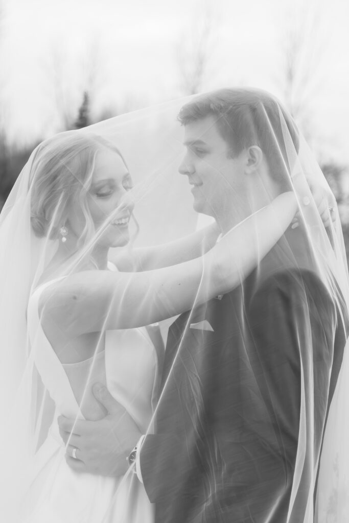 bride and groom under wedding veil outside The Palazzo Grande, a wedding venue in Sterling Heights Michigan