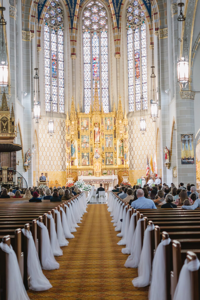 bride and groom sitting in front of altar inside St Florian Catholic Church, a Detroit Michigan church