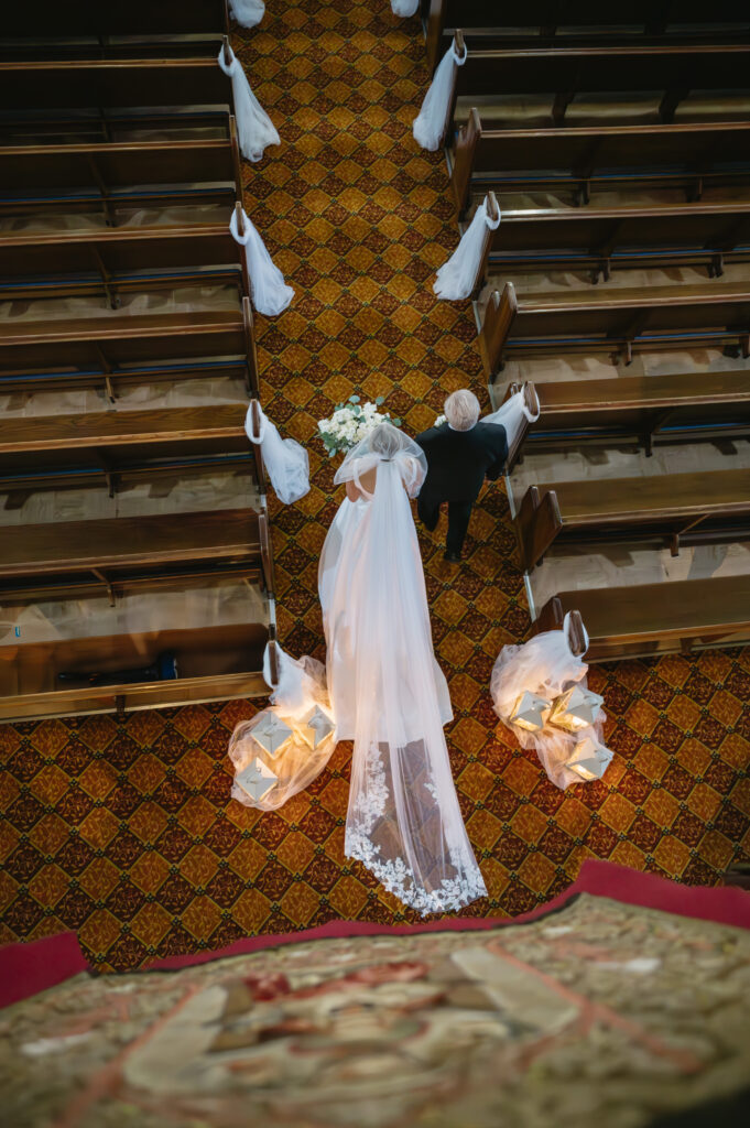 father walking bride down the aisle for wedding ceremony at St. Florian Catholic Church, located in Detroit Michigan