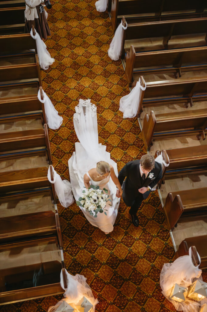 bride and groom walking down aisle after wedding ceremony at St Florian Catholic Church, located in Hamtramck Michigan