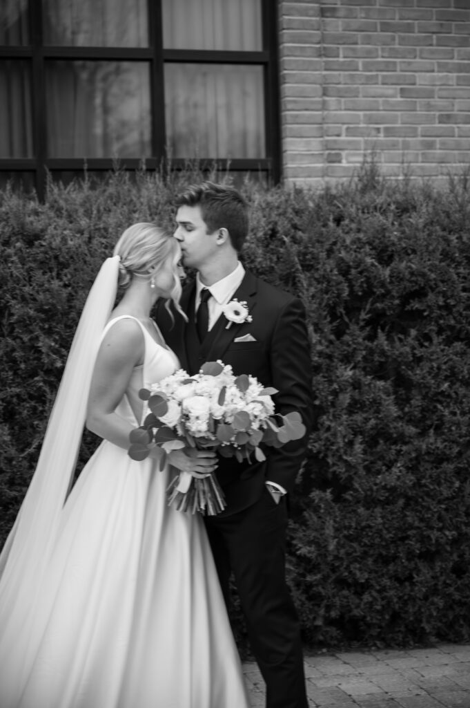 married couple kissing in front of The Palazzo Grande, a wedding venue in Sterling Heights Michigan