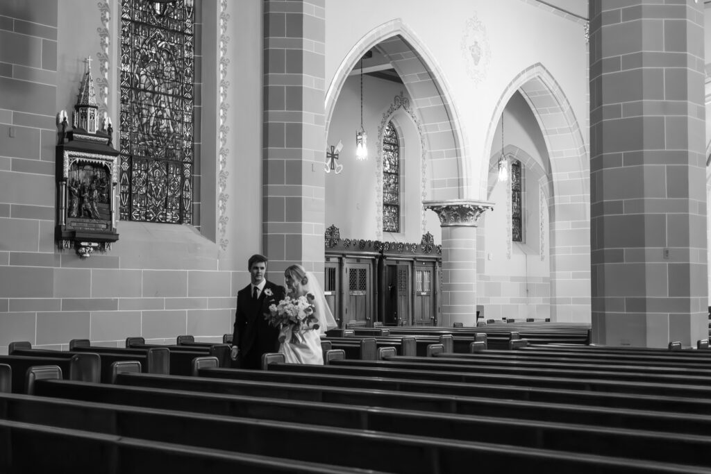 married couple walking through pews in St Florian Catholic Church, a Detroit Michigan wedding spot