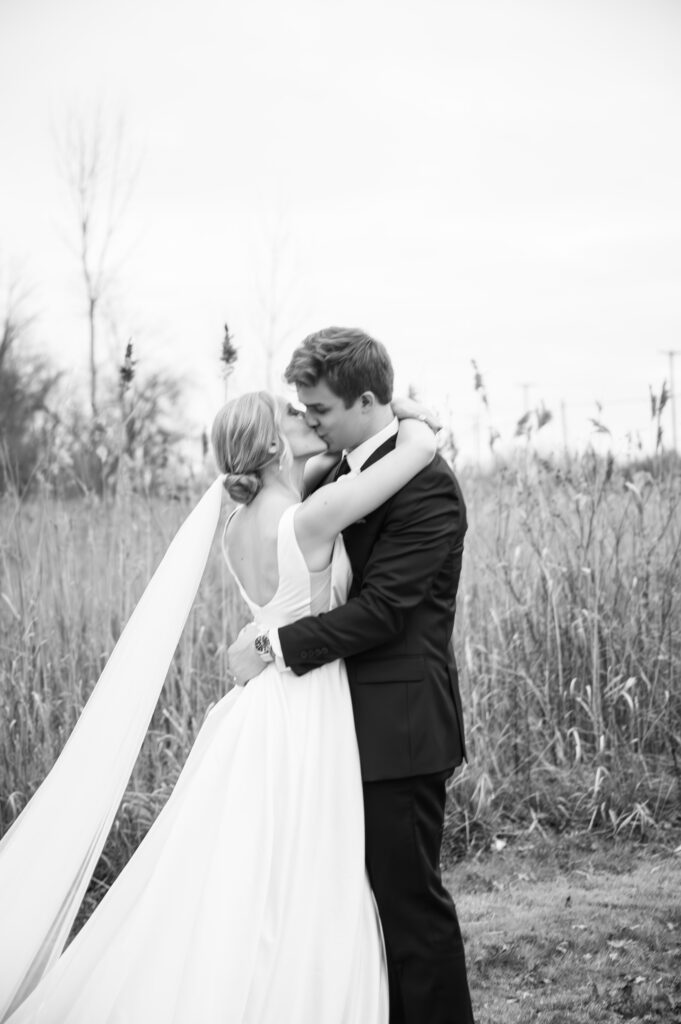 bride and groom kissing in open field near Sterling Heights Michigan