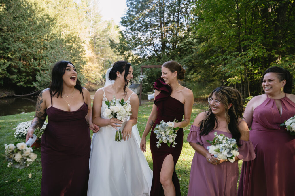 bridesmaids laughing outside of barn wedding venue