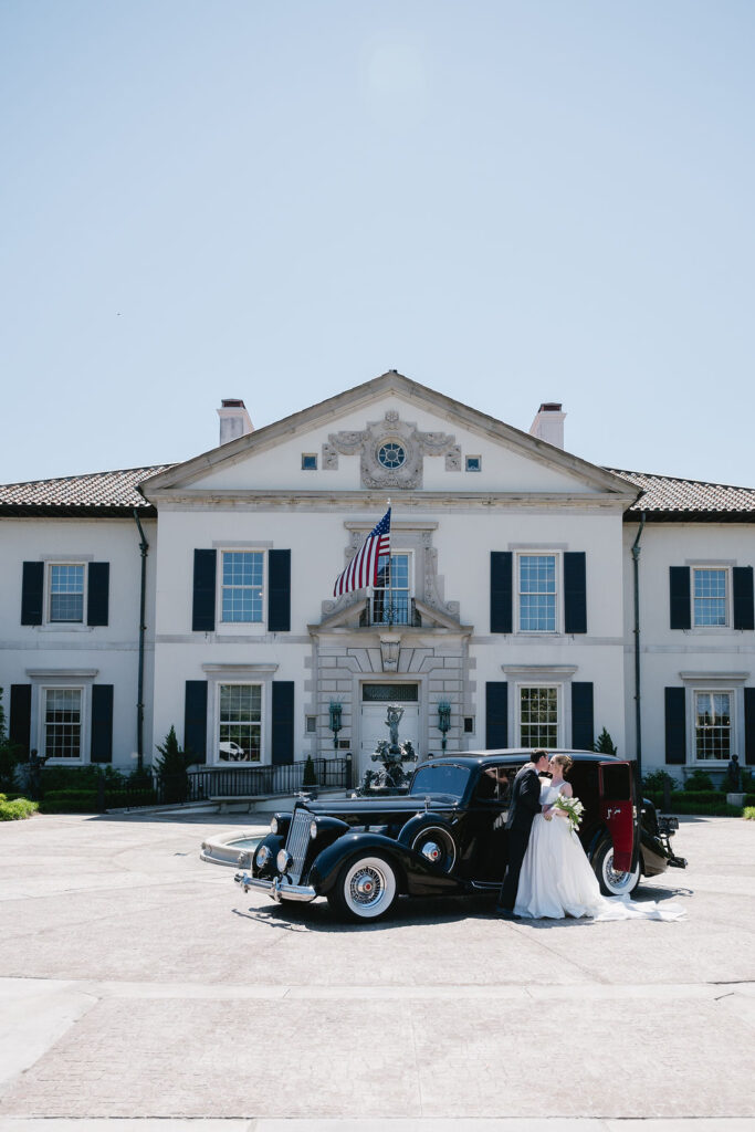 couple and vintage car in front of michigan wedding venue