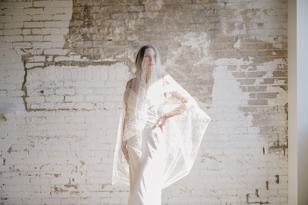 bride standing in harsh lighting in The Dealership, a wedding venue in Oxford Michigan