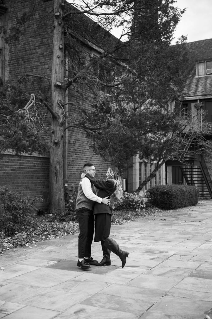 engaged couple twirling outside Meadowbrook Hall, a Rochester Michigan wedding venue