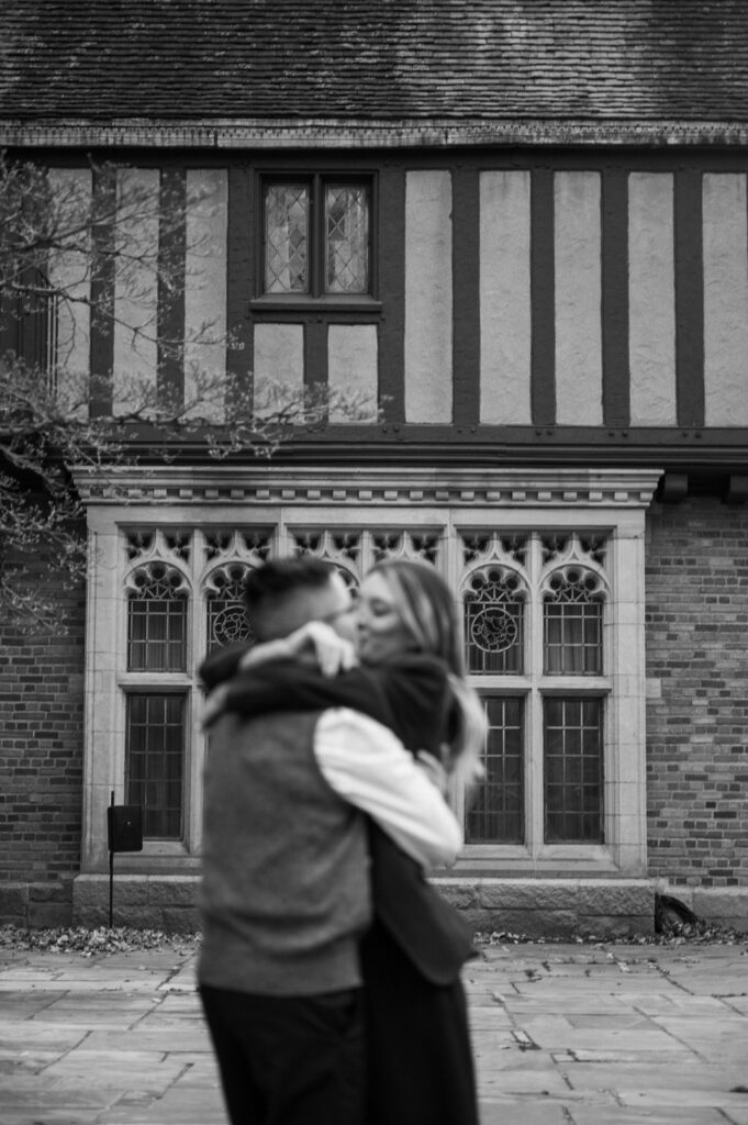 engaged couple kissing outside of Meadowbrook Hall, a wedding venue in Rochester Michigan