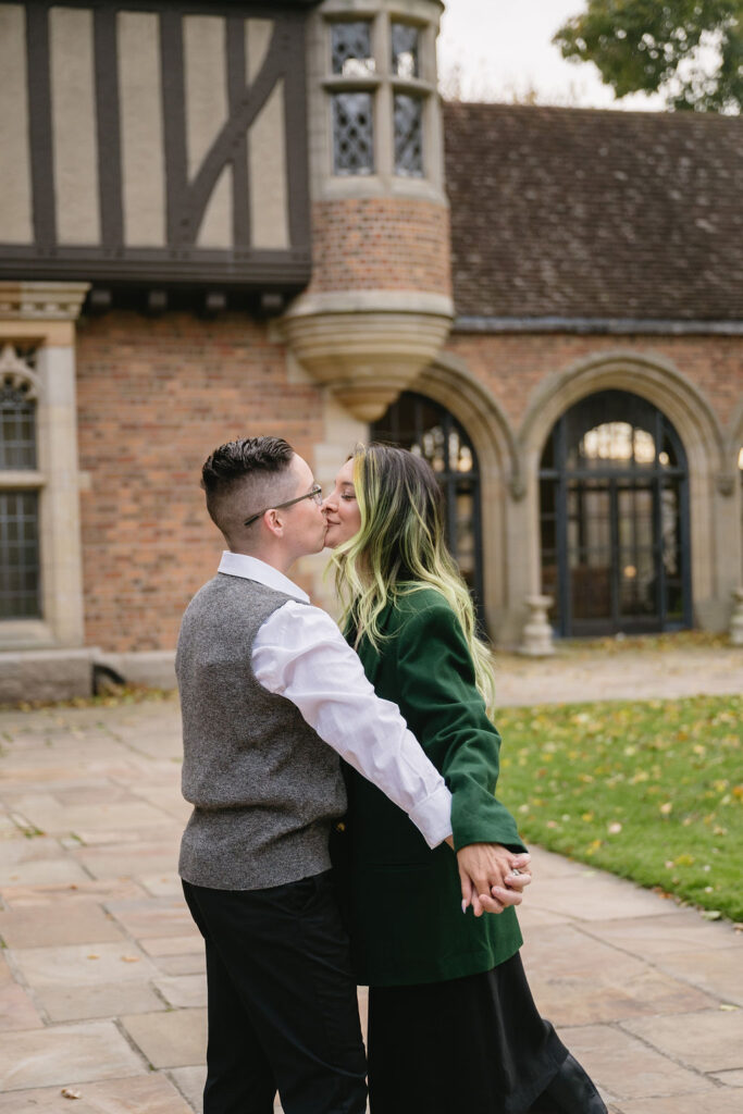 engaged couple kissing outside of Meadowbrook Hall, a wedding venue in Rochester Michigan