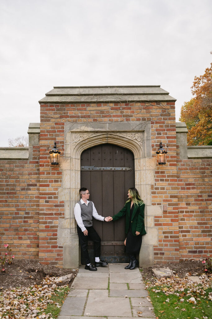 engaged couple holding hands outside of Meadowbrook Hall, a wedding venue in Rochester Michigan