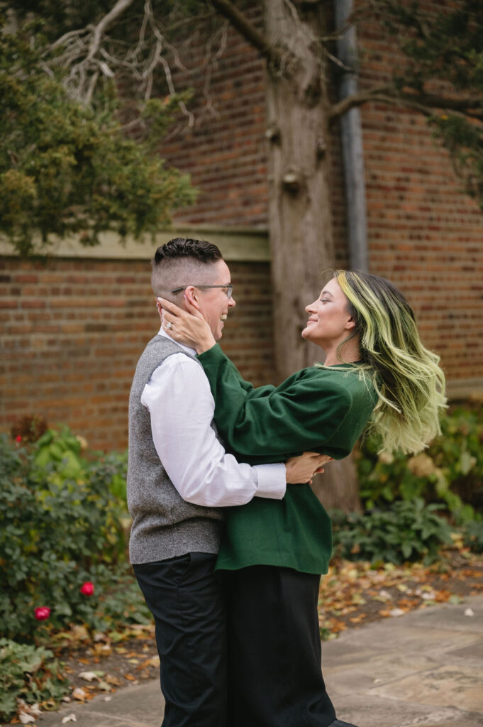 engaged couple hugging outside Meadowbrook Hall, a wedding venue in Rochester Michigan