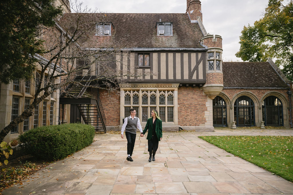 engaged couple walking outside of Meadowbrook Hall, a wedding venue in Rochester Michigan