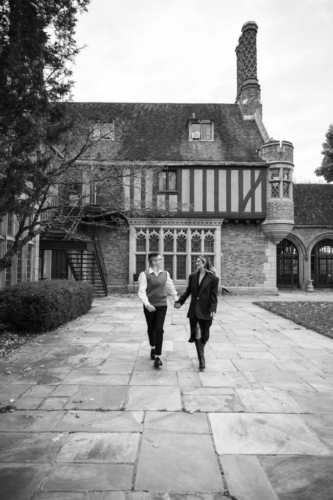 engaged couple walking outside of Meadowbrook Hall, a wedding venue in Rochester Michigan