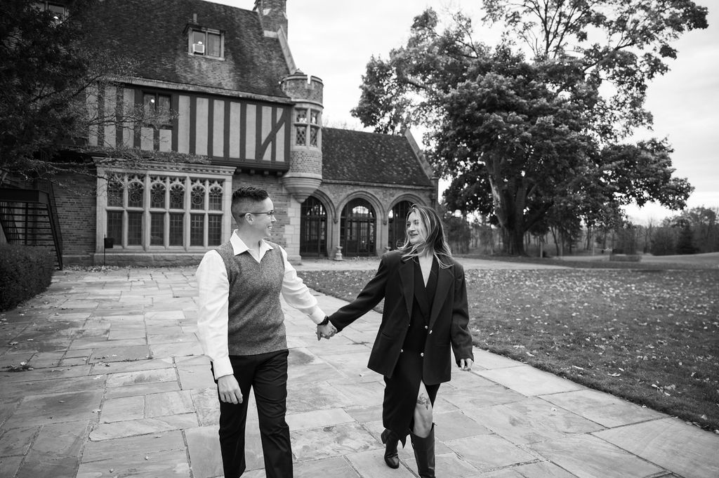 engaged couple walking outside of Meadowbrook Hall, a wedding venue in Rochester Michigan