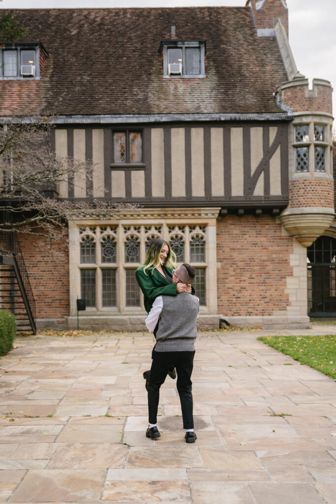 engaged couple twirling outside of Meadowbrook Hall, a wedding venue in Rochester Michigan