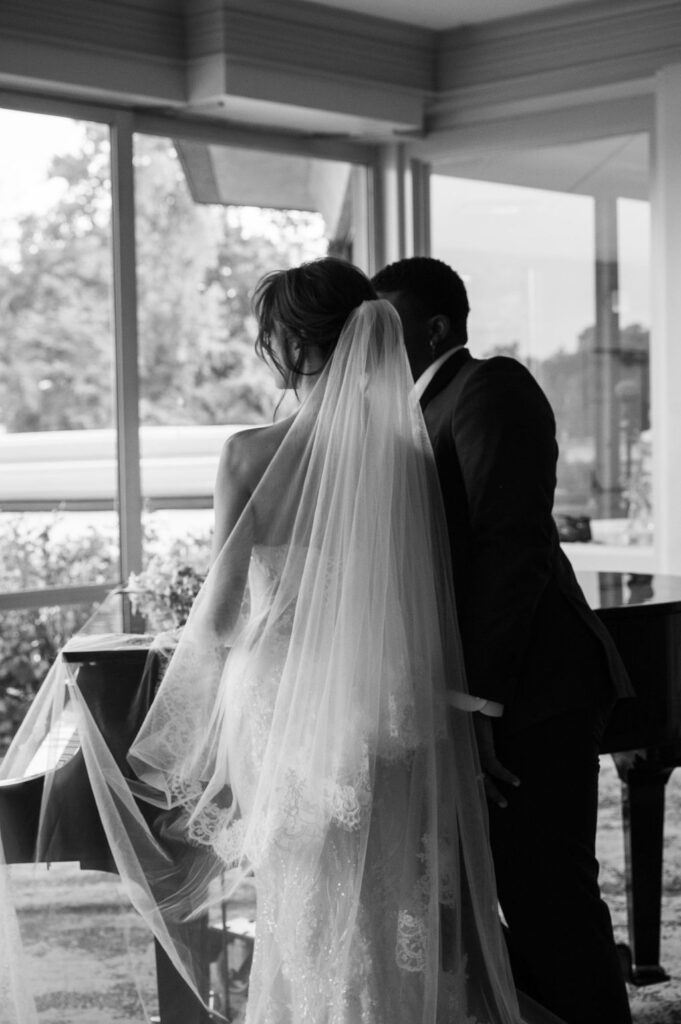 bride and groom standing at piano