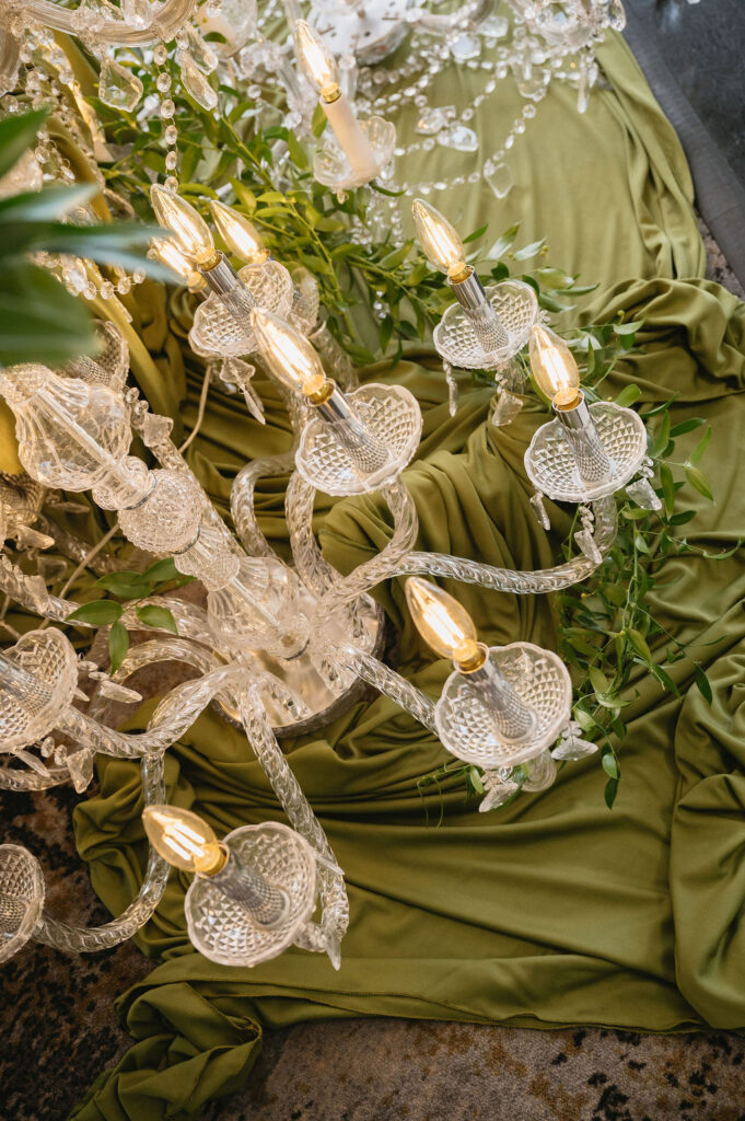 chandelier sitting on olive green drapes