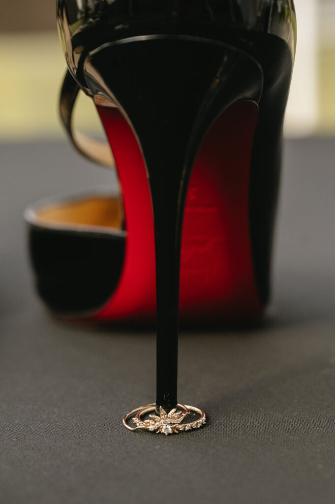 wedding rings stacked on black Louboutin heel