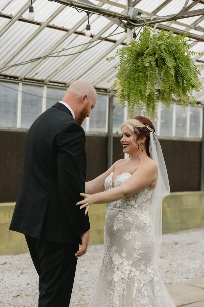 bride and groom first look in greenhouse