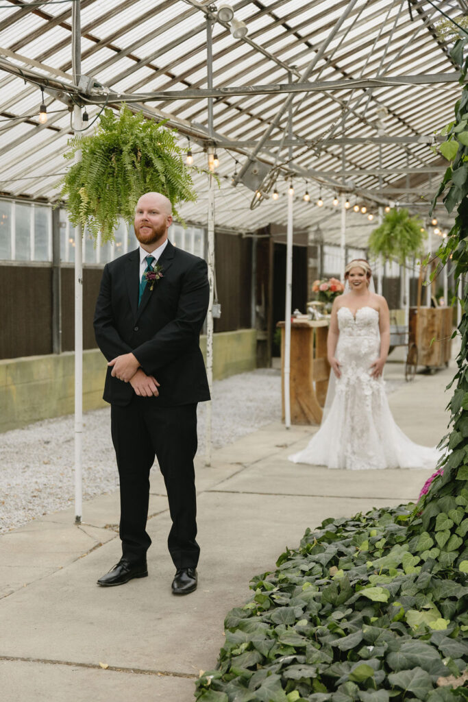 bride and groom first look in greenhouse