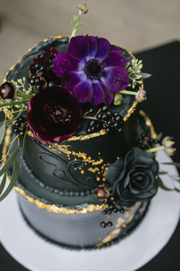 black wedding cake with purple flowers