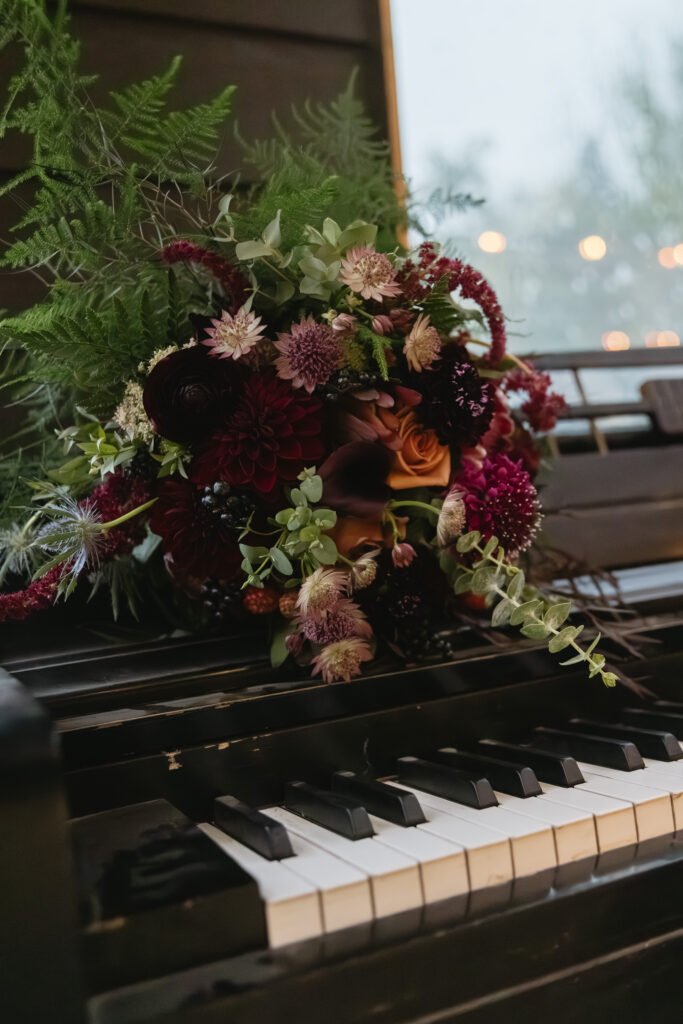 burgandy bridal bouquet on a piano