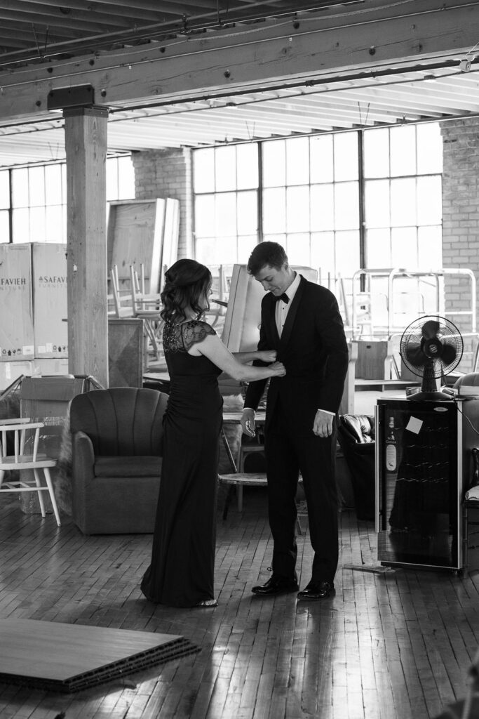 mother of groom helping adjust his suit