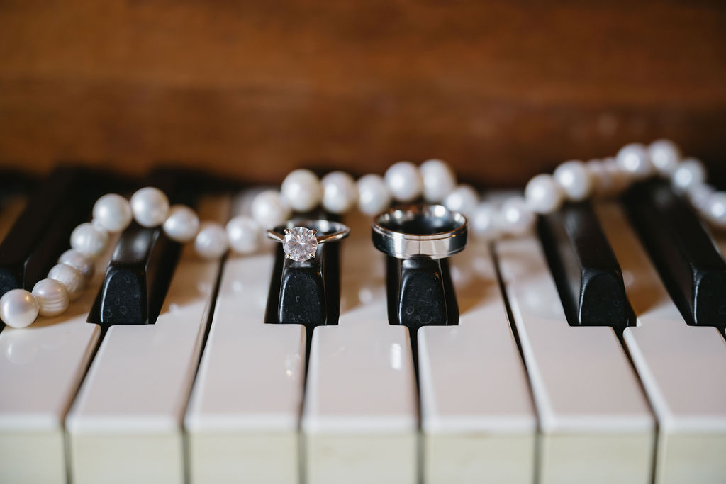 wedding rings sitting on piano keys