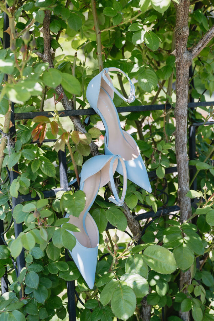 blue high heels hanging off garden arbor