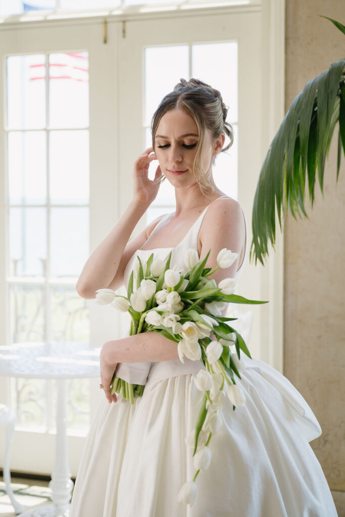 bride holding white tulips inside war memorial wedding venue