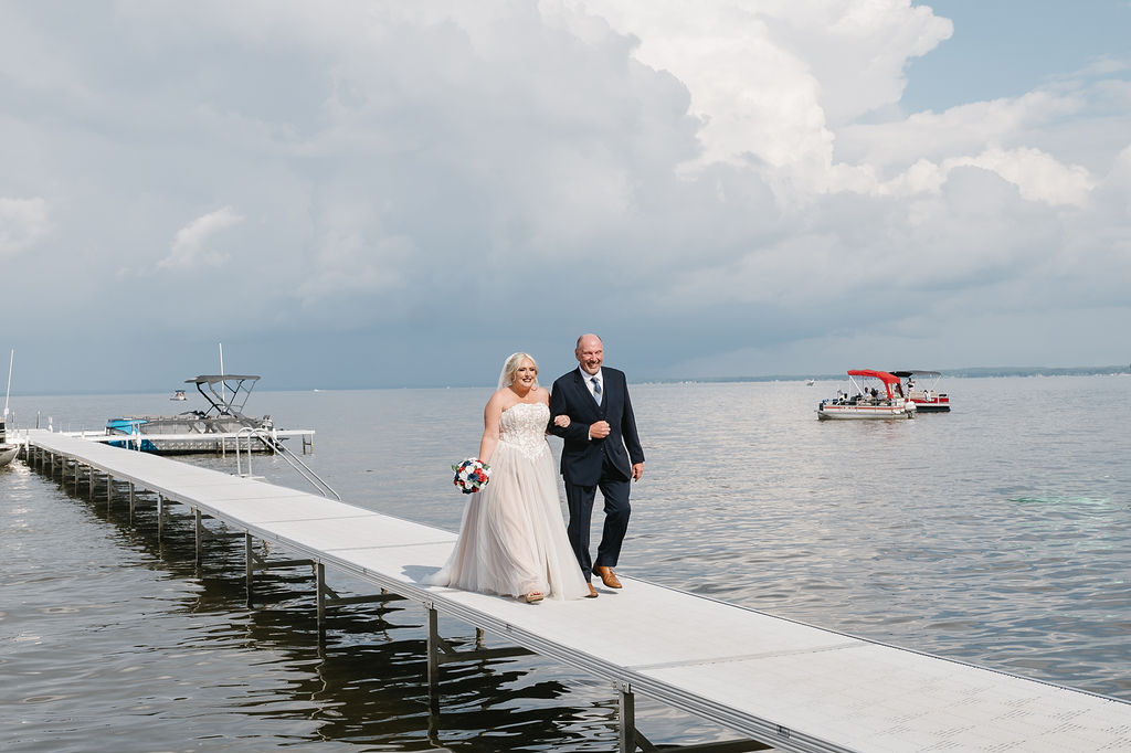 bride walking down lake dock