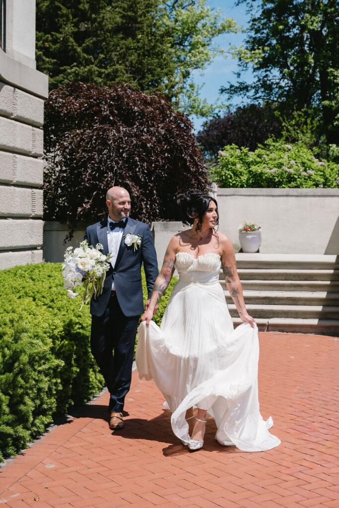 bride and groom walking outside lakefront venue