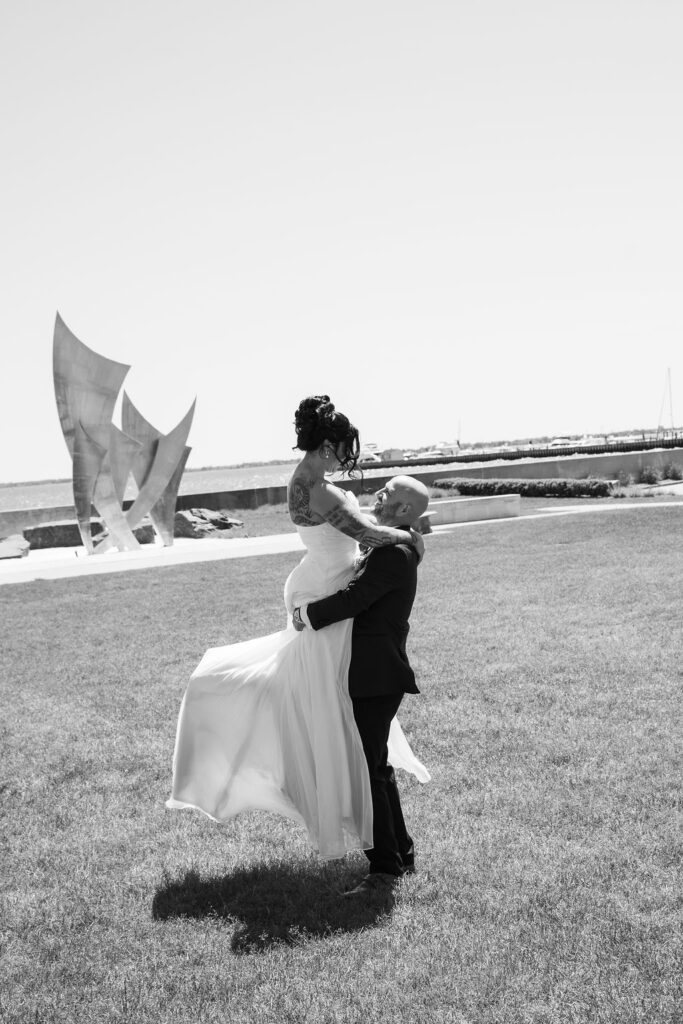 bride and groom twirling in front of lake