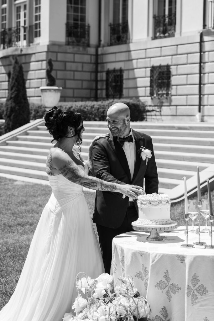 bride and groom cutting cake at lakefront wedding venue