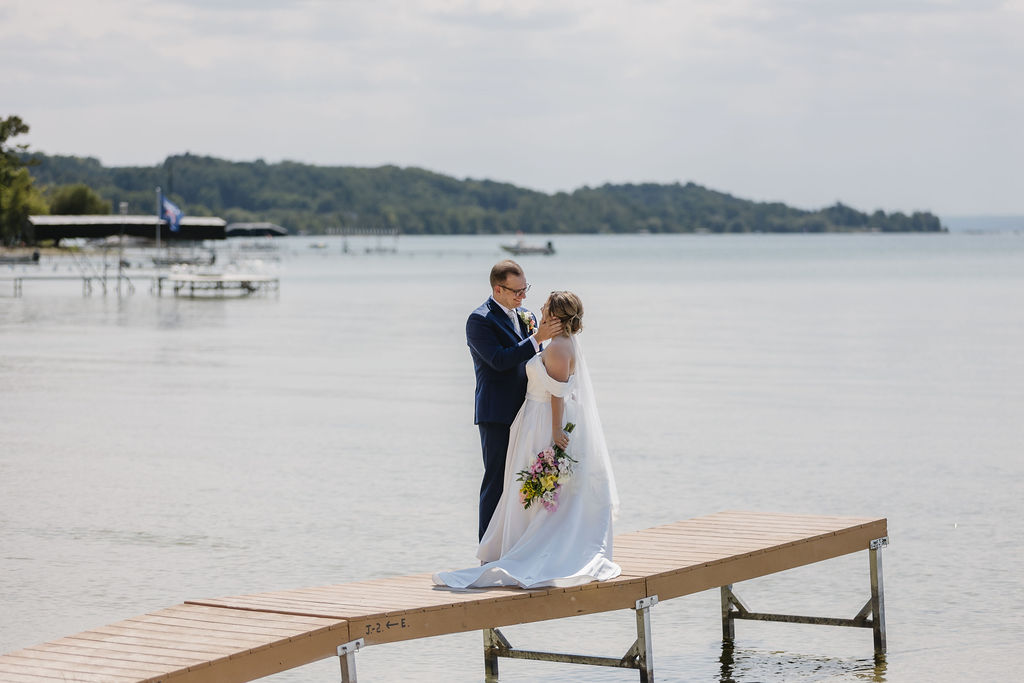 bride and groom standing on lake dock in northern michigan