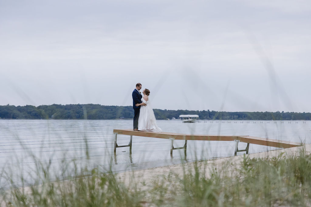 bride and groom standing on lake dock in northern michigan