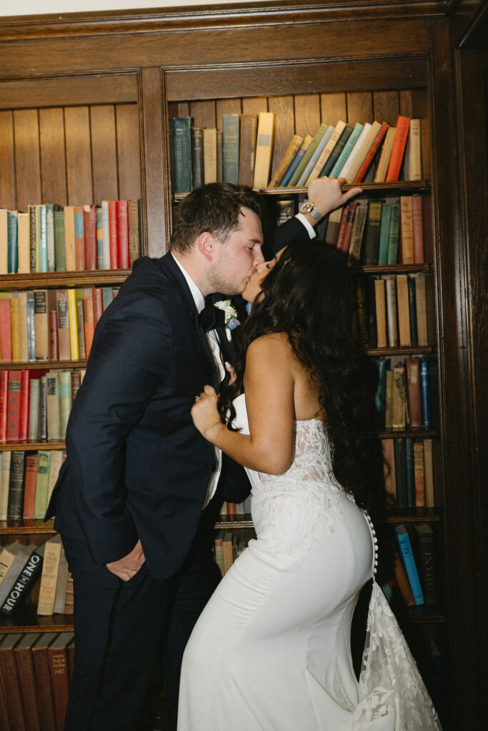 bride and groom kissing in library