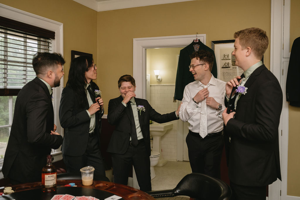 groom getting dressed with groomsmen