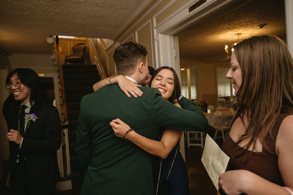 groom hugging wedding guest