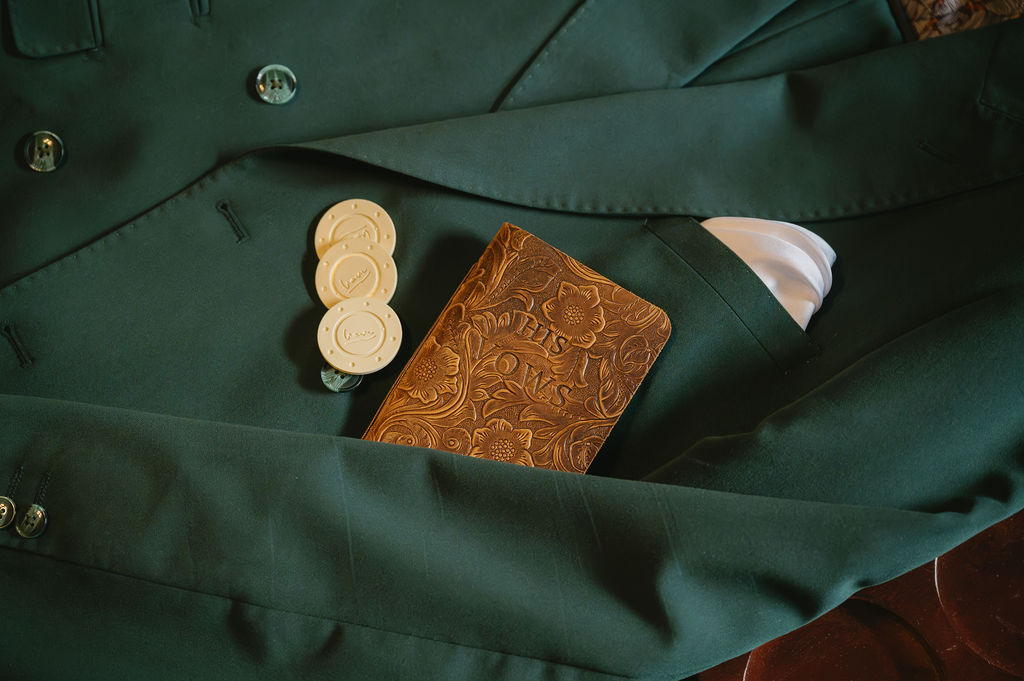 poker chips and leather vow book on green suit jacket