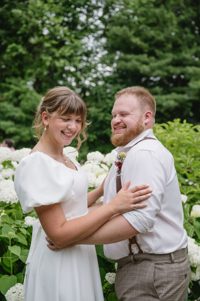 bride and groom in front of hydrangeas