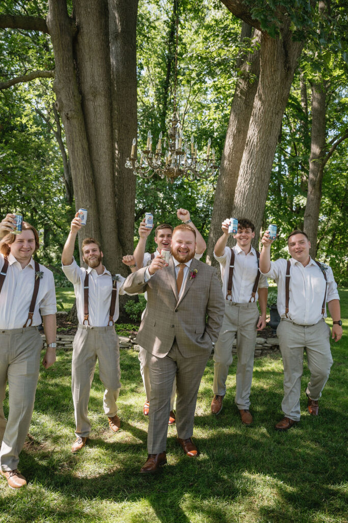 groom and groomsmen cheering drinks