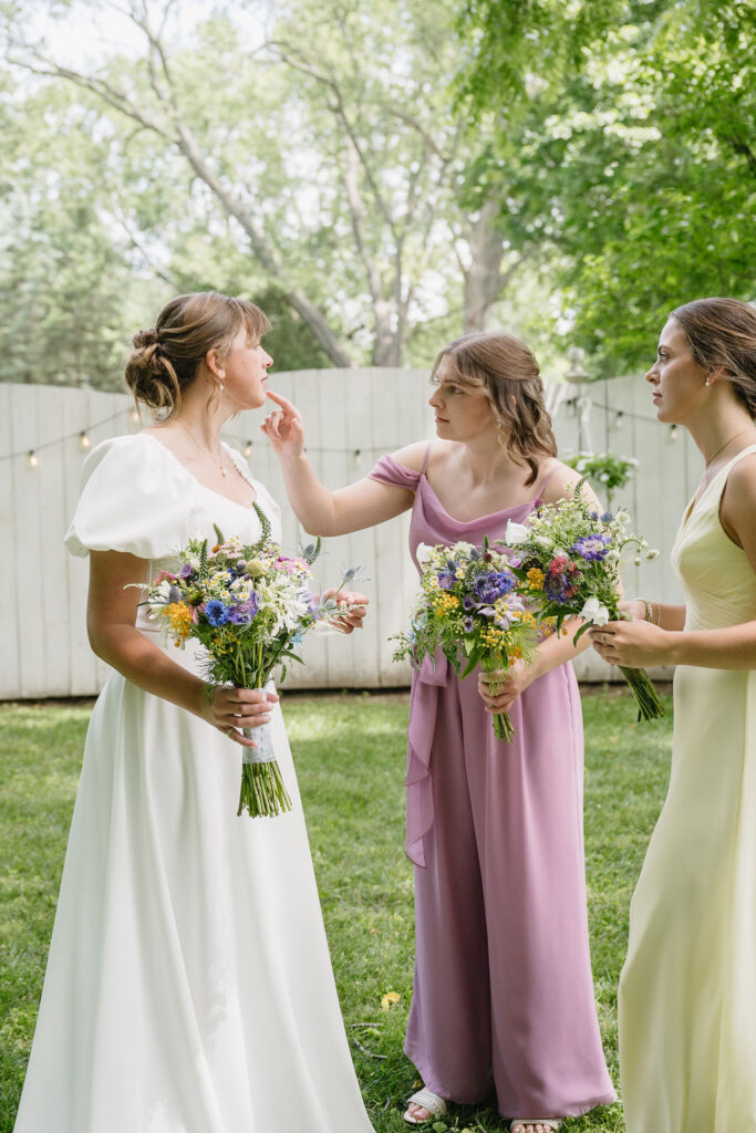 bridesmaid fixing bride's makeup